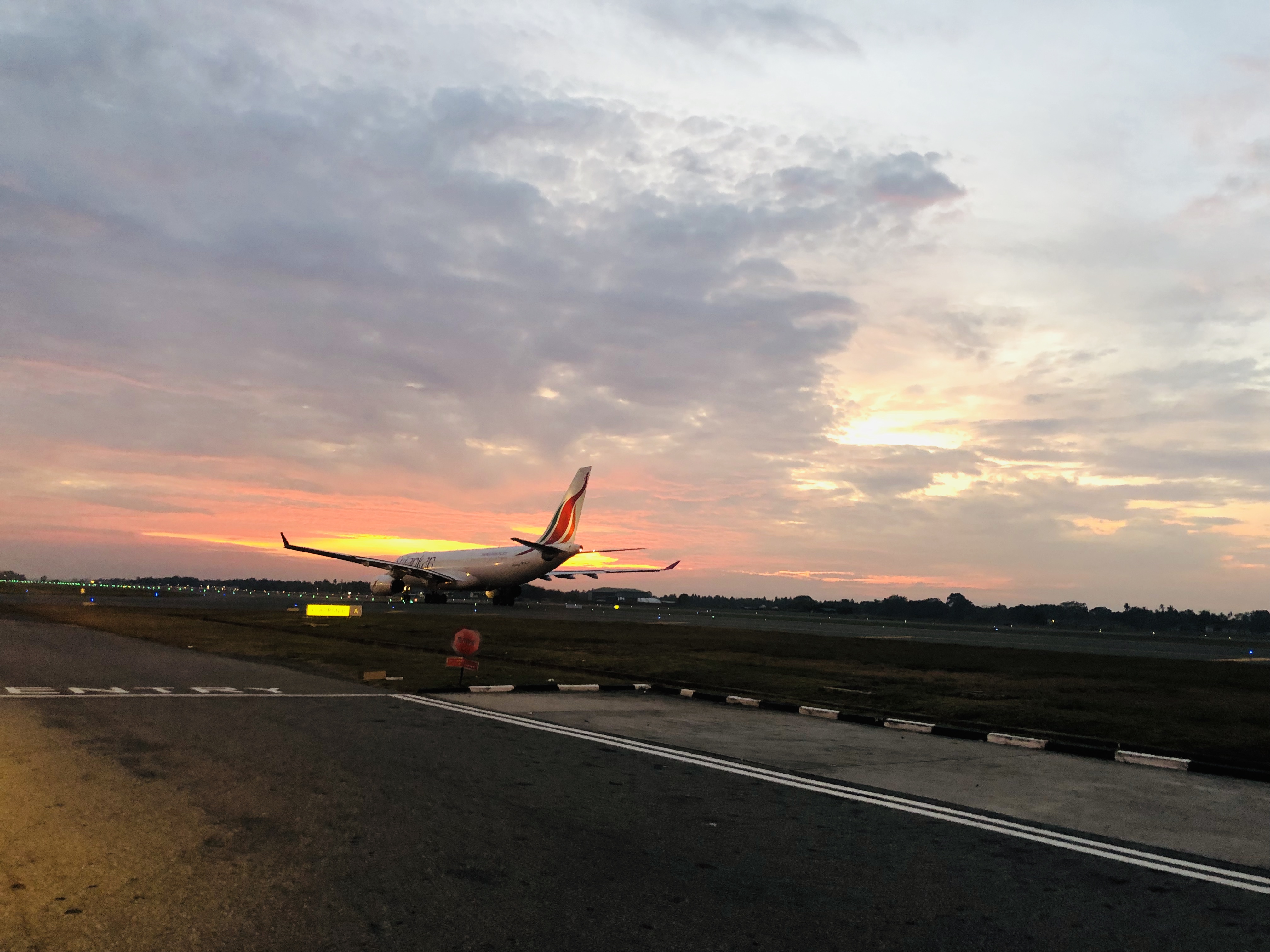 Aircraft on an airport runway at sunset