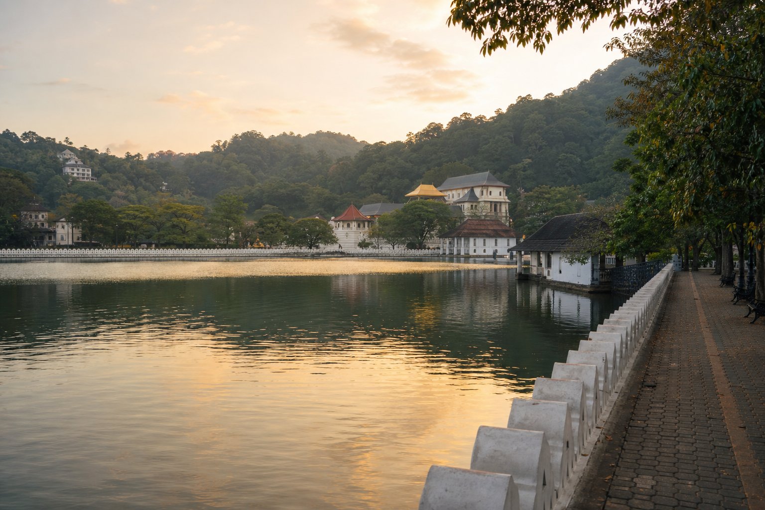 Kandy Lake at golden hour — temple roofs across the water from the lakeside path